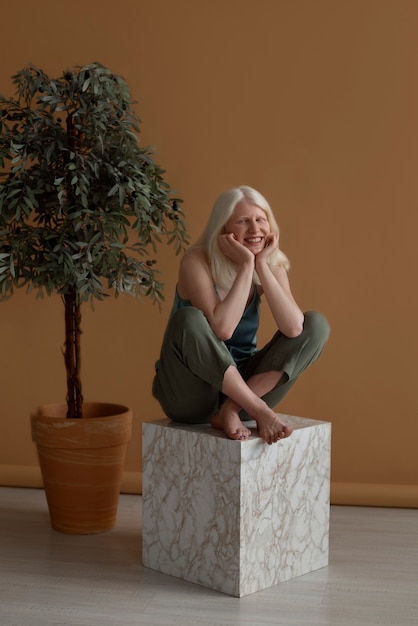 Mulher de tiro completo com albinismo posando no estúdio