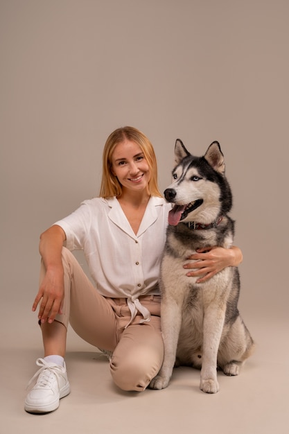 Mulher de tiro completo com cachorro em estúdio