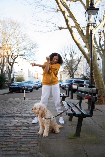 Mulher de tiro completo com cachorro fofo ao ar livre