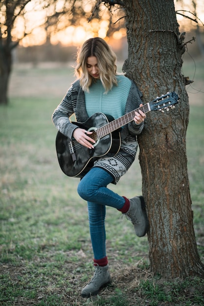 Mulher de tiro completo com guitarra