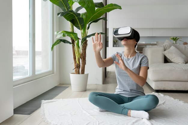 Mulher de tiro completo com óculos vr no chão