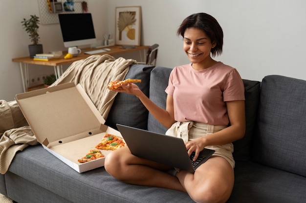 Mulher de tiro completo comendo pizza deliciosa