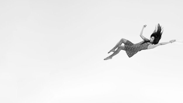 Mulher de tiro completo em vestido em tons de cinza flutuante
