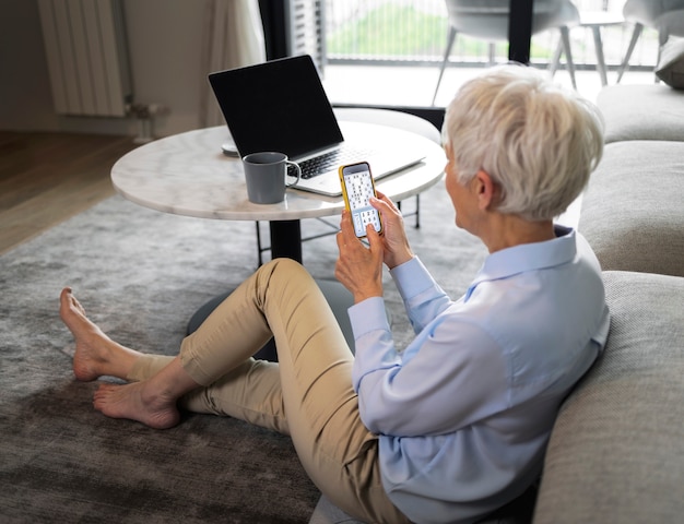 Foto grátis mulher de tiro completo fazendo uma pausa com smartphone