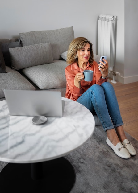 Foto grátis mulher de tiro completo fazendo uma pausa com smartphone