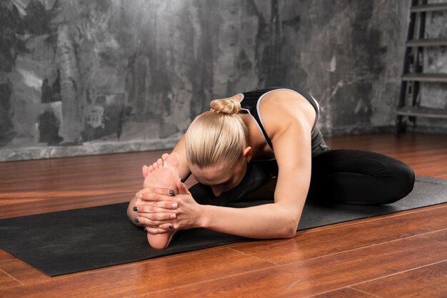 Mulher de tiro completo fazendo yoga em casa