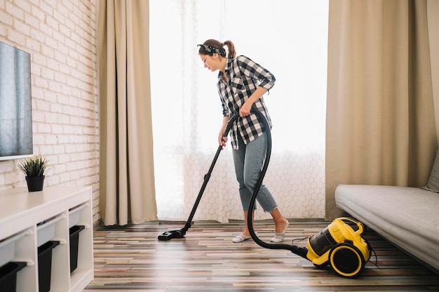 Foto grátis mulher de tiro completo limpando a sala de estar