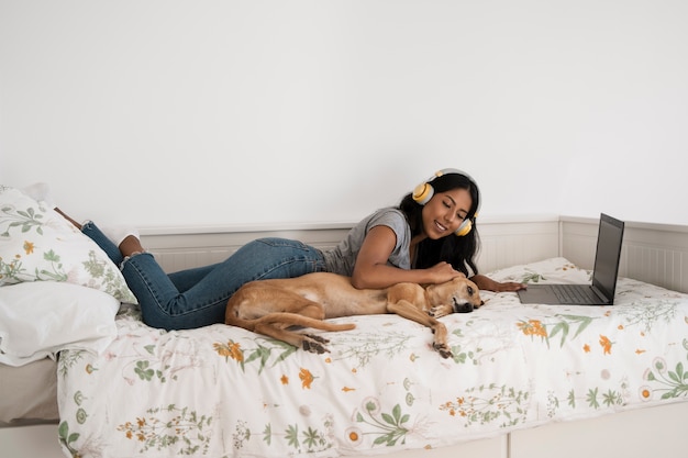 Foto grátis mulher de tiro completo na cama com cachorro