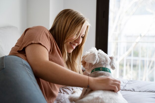 Mulher de tiro médio a acariciar um cão