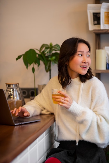 Mulher de tiro médio a beber kombucha.