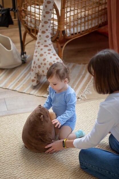 Foto grátis mulher de tiro médio brincando com bebê