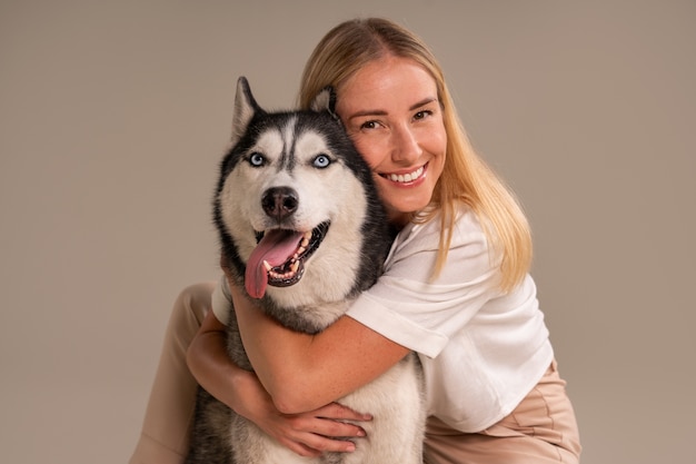 Foto grátis mulher de tiro médio com cachorro em estúdio