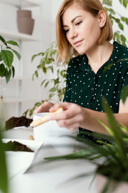 Mulher de tiro médio com espátula de jardinagem