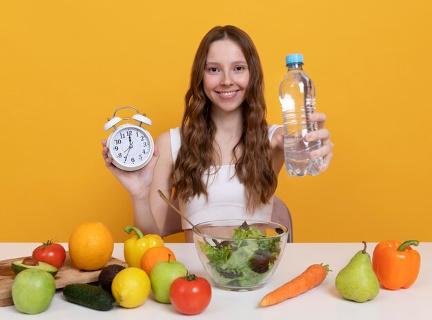 Foto grátis mulher de tiro médio com legumes e água