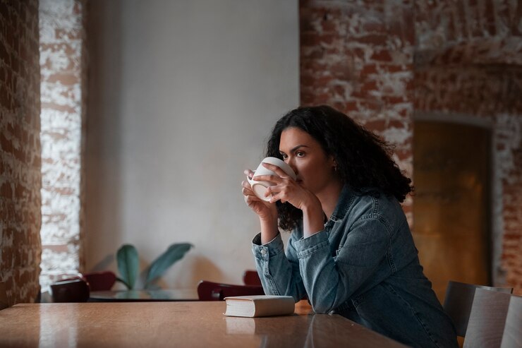 Foto grátis mulher de tiro médio com livro na cafeteria