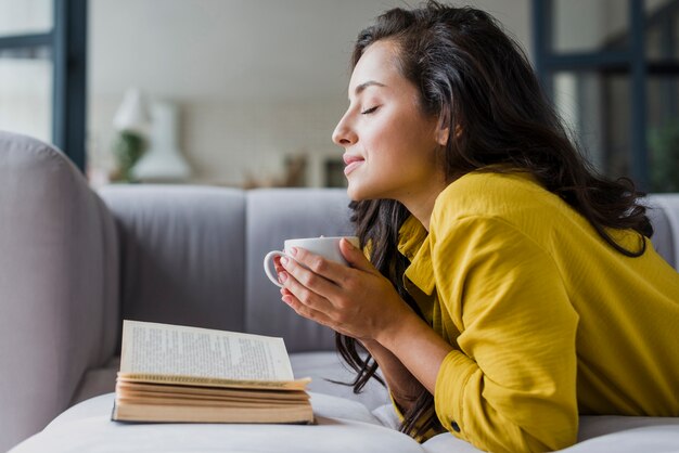 Mulher de tiro médio com os olhos fechados e livro