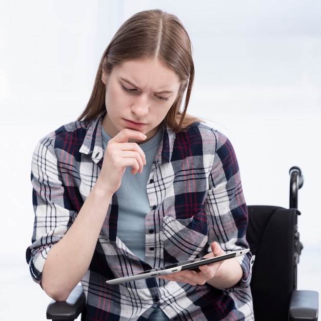 Mulher de tiro médio com pensamento de tablet