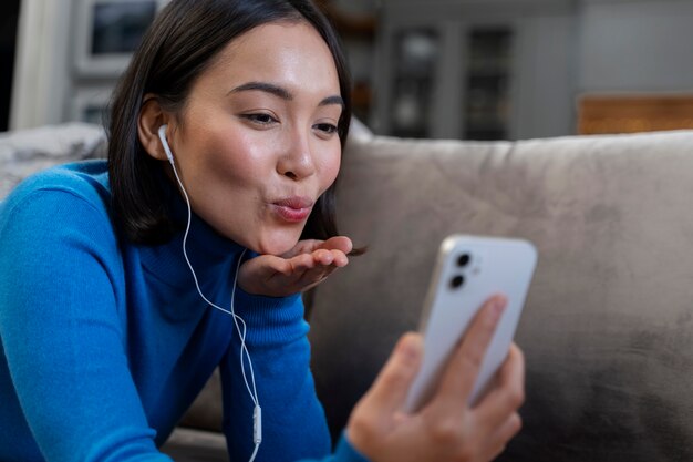 Mulher de tiro médio com telefone em casa