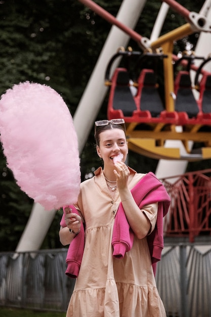 Foto grátis mulher de tiro médio comendo algodão doce gigante