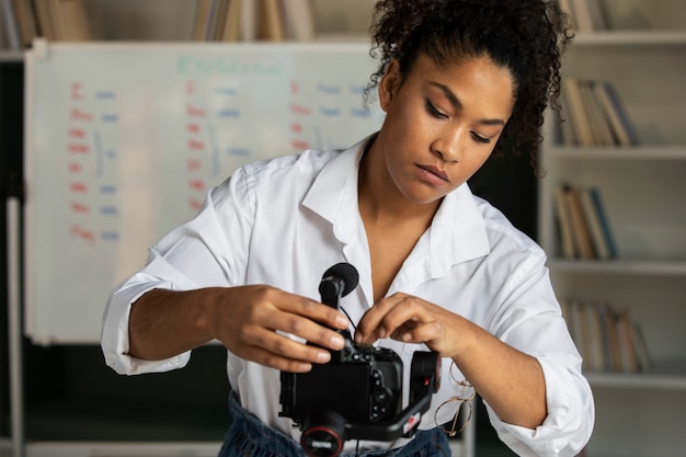 Foto grátis mulher de tiro médio configurando a câmera