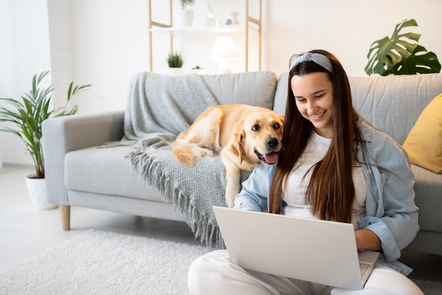 Foto grátis mulher de tiro médio e cachorro fofo dentro de casa