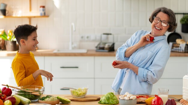 Mulher de tiro médio e criança cozinhando juntos