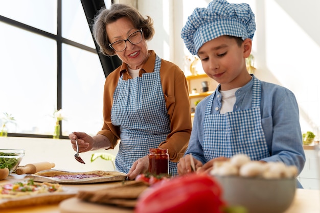 Foto grátis mulher de tiro médio e criança cozinhando juntos