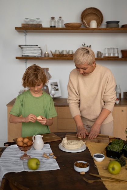 Mulher de tiro médio e criança preparando comida