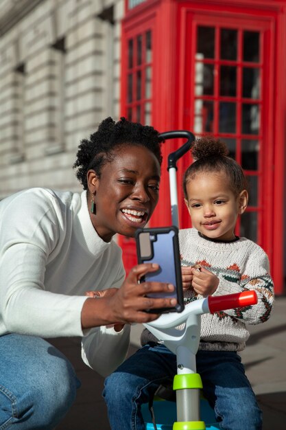 Mulher de tiro médio e criança tomando selfie