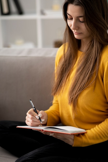 Mulher de tiro médio escrevendo no notebook