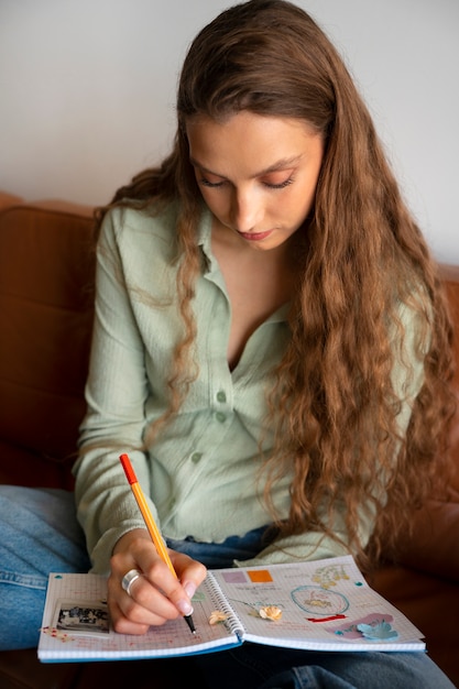 Mulher de tiro médio fazendo diário criativo