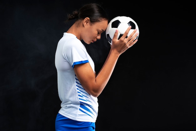 Mulher de tiro médio jogando futebol