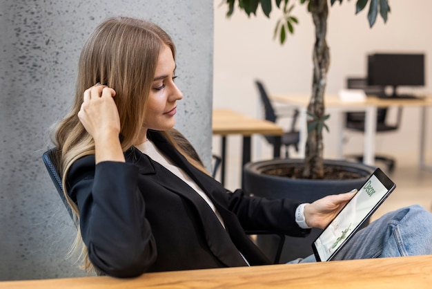 Foto grátis mulher de tiro médio lendo revista digital