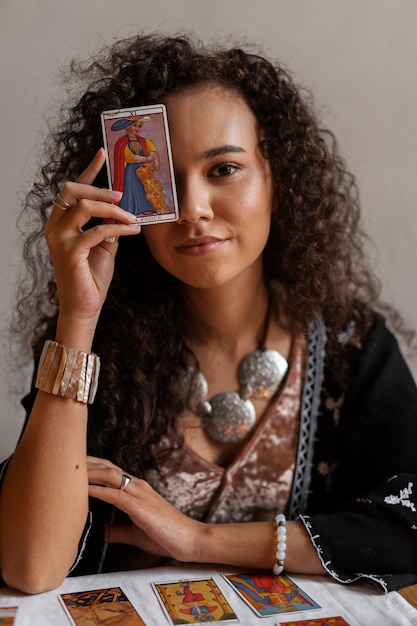 Mulher de tiro médio lendo tarô em casa