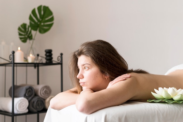 Mulher de tiro médio na mesa de massagem