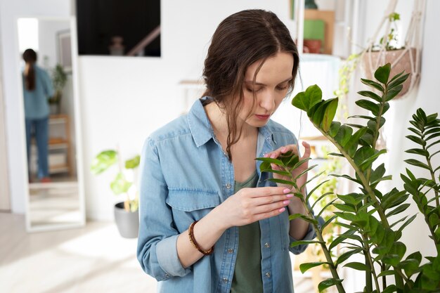 Mulher de tiro médio olhando para a planta