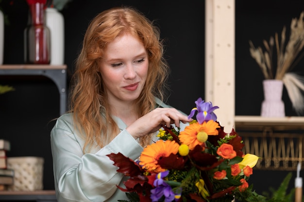 Foto grátis mulher de tiro médio olhando para flores