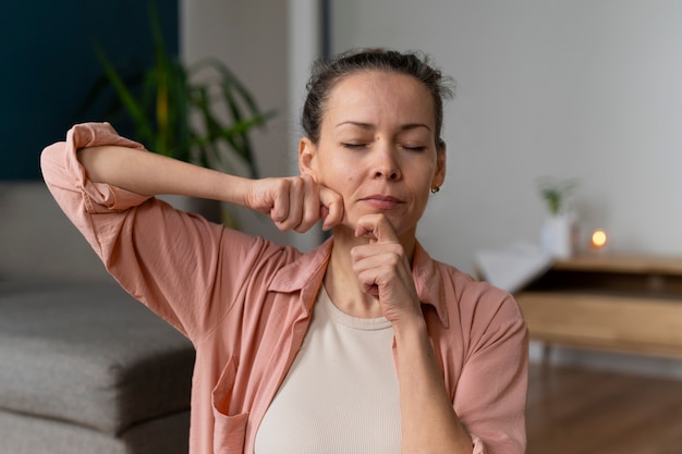 Foto grátis mulher de tiro médio praticando ioga facial