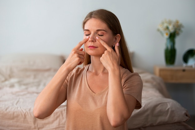 Foto grátis mulher de tiro médio praticando ioga facial