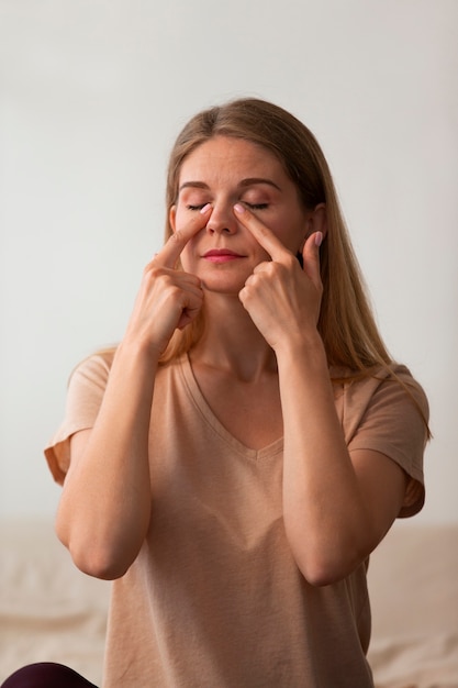 Mulher de tiro médio praticando ioga facial