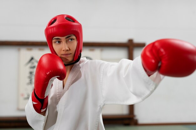 Mulher de tiro médio praticando taekwondo