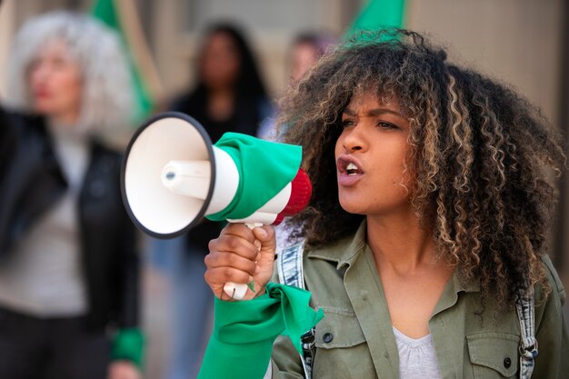 Mulher de tiro médio protestando ao ar livre