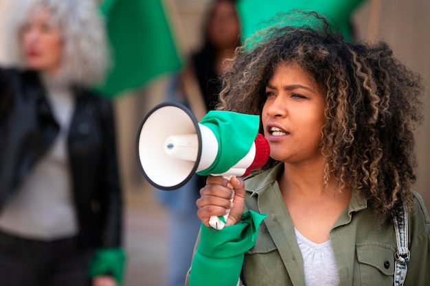 Foto grátis mulher de tiro médio protestando ao ar livre