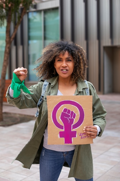 Mulher de tiro médio protestando ao ar livre