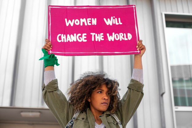 Mulher de tiro médio protestando ao ar livre
