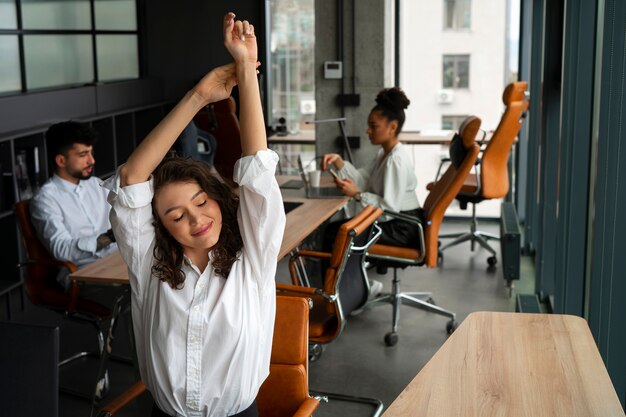 Mulher de tiro médio se alongando no trabalho