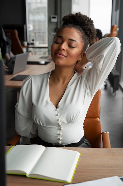 Foto grátis mulher de tiro médio se alongando no trabalho