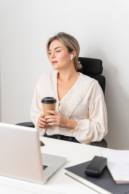 Mulher de tiro médio segurando a xícara de café