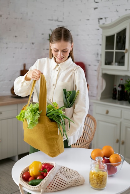 Foto grátis mulher de tiro médio segurando bolsa de lona