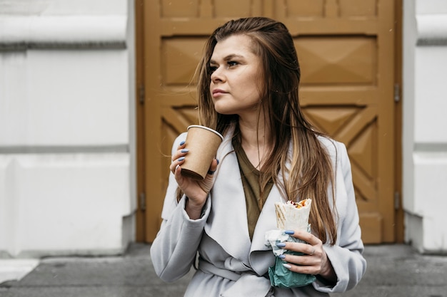 Mulher de tiro médio segurando kebab